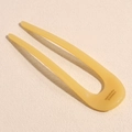 Dettaglio di una forcina a U in acetato color miele con logo France Handmade inciso - Giallo