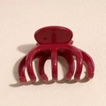 Macro view of a glossy wine red claw clip on a textured beige surface background - Hollow Claw Hair Clip