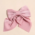 Dettaglio fermaglio per capelli con fiocco in raso rosa e nastri con texture setosa - Rosa