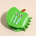 Detail view of the glossy green apple-shaped hair claw clip with a sad crying face - Apple Green