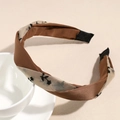 Detail van vintage Franse haarband met zwart geborduurde kant over bruin satijnen stof - Klein Bloemen Bruin