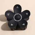 Detail van zwarte bloem haarclip met sprankelende strassteentjes op matte bloemblaadjes - Zwart