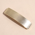 Dettaglio del fermaglio per capelli dorato in metallo con trama lineare e design ad arco - Quadrato Oro