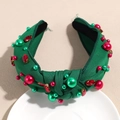 Gros plan d'un serre-tête noué vert avec strass rouges et perles de Noël - Perle Strass Vert