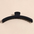 Close-up of matte black large shark clip with dense teeth for thick hair styling - Black