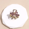 Vista macro de una pinza para el pelo dorada con lazo de diamantes de imitación púrpuras - Forma de Mariposa (5832845670607) / Strass Rosa Púrpura