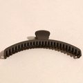 Macro side view of a large matte dark brown hair claw clip showing dense round comb teeth - Coffee
