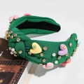 Close-up of green knotted headband with colorful hearts, pearls and sparkling crystals - Green