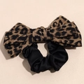 Macro detail of leopard print bow scrunchie with silky texture and animal pattern design - Leopard Scrunchie