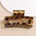 Detail of a rectangular tortoiseshell hair claw clip with leopard pattern and metal spring - Square