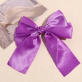 Detail of a large dark purple satin bow hair clip with double layers and long ribbons - Purple