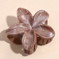 Macro shot of a floral hair claw with brown marble texture and glossy resin finish - Glitter Coffee