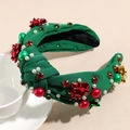 Primer plano de diadema navideña verde con lazos rojos y pedrería de colores brillante - Verde con Flor
