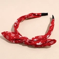 Dettaglio cerchietto in tessuto rosso con fiocco e stampe di fiocchi di neve natalizi - Rosso Stella Fiocco di Neve