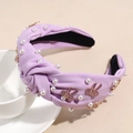 Close-up of light purple knotted headband with white pearls and enamel bow charms - Light Purple