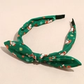 Detail of green Christmas headband with Santa print and large fabric bow tie - Green