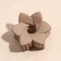 Dettaglio ravvicinato di una molletta a fiore beige opaco su sfondo in pietra neutra - Fiore a Spirale Cachi Opaco