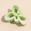 Macro shot of light green curved hair claw clip with glossy finish and metal spring - Butterfly Green