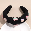 Detailansicht eines breiten Stoffstirnbands mit bunten 3D-Herzanhängern und LOVE-Prägung - Schwarz