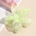 Detail of a translucent light green flower hair claw clip on a textured beige surface - Light Green