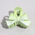 Detailed view of a mint green plastic bow hair clip with a metallic spring mechanism - Bow Green