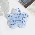 Dettaglio molletta per capelli a fiore azzurro con glitter in un ambiente lifestyle - Fiore Blu