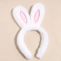 Detalle de diadema de orejas de conejo de felpa blanca con forro rosa sobre beige - Orejas de Conejo Blancas