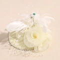 Dettaglio di un elegante fascinator verde chiaro con piume bianche e perle decorative - Fiore Piuma Bianco Crema