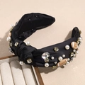 Detail view of black satin knotted headband with pearls, rhinestones and football charms - Black