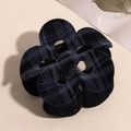 Detail view of black flocked checkered plumeria hair claw clip with velvet texture - Hollow Black Flower