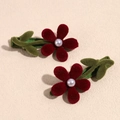 Dettaglio macro di fermagli per capelli a fiori rossi con perle su superficie ruvida - Coppia di Grandi Fiori