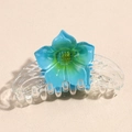 Close-up of translucent blue-green gradient flower hair claw clip with multi-tooth design - Blue