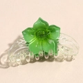 Detail of a large green translucent resin flower hair claw clip with floral texture - Green