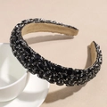 Macro shot of black rhinestones on a wide velvet headband with silver metal settings - Black