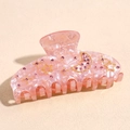 Detailed view of pink acetate hair claw clip with golden moon and rhinestone star patterns - Orange