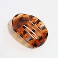 Close-up of tortoise shell pattern oval hair claw clip with internal grip teeth - Translucent Yellow Brown Leopard