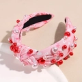 Detalle de diadema de tela rosa con estampado LOVE, corazones rojos y perlas artificiales - Rosa LOVE