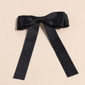 Close-up of elegant black satin ribbon bow hair clip with long streamers on beige surface - Black