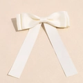 Detail view of cream white satin ribbon bow clip with elegant silky texture - Off White