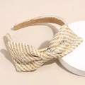 Close-up of yellow and green raffia bow headband with woven texture on a white stand - Woven Beige
