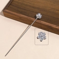Detailed macro view of translucent floral petals and silver metallic pin on hair stick - Lotus