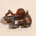 Dettaglio macro della molletta per capelli a forma di elefante con texture tartarugata - Cane Ambra
