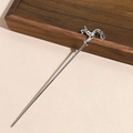 Detail of silver faucet hair pin with water drop pendant on a textured background - Creative Faucet Style