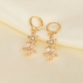 Elegant gold flower earrings with sparkling zircons on cream silk background - Gold