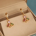 Makroaufnahme goldener geometrischer Ohrringe mit rosa, roten und grünen Zirkoniasteinen - Dreifarben Edelstein Stil (CZ144)