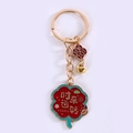 Nahaufnahme vom vergoldeten Schlüsselanhänger mit roter Blume und Ingot-Anhänger - Glückswechsel Ring