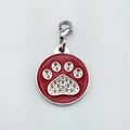 Macro detail of red enamel round pet tag with silver paw print and crystal accents - Claw Print / Red