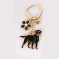 Golden keychain with black Labrador pendant, flower with pearl, and heart charm - Black Golden Retriever With Black Flower