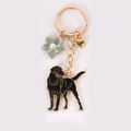 Golden Labrador dog keychain with black enamel, blue flower and small gold heart charm - Turned Head Black Golden Retriever With Blue Flower