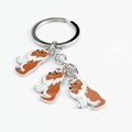 Detail van metalen hondensleutelhanger met drie emaille hangers van een collie - Sheltie Bedel
